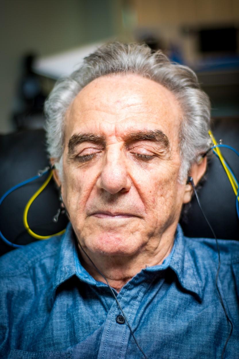 An older adult relaxes with eyes closed during a session