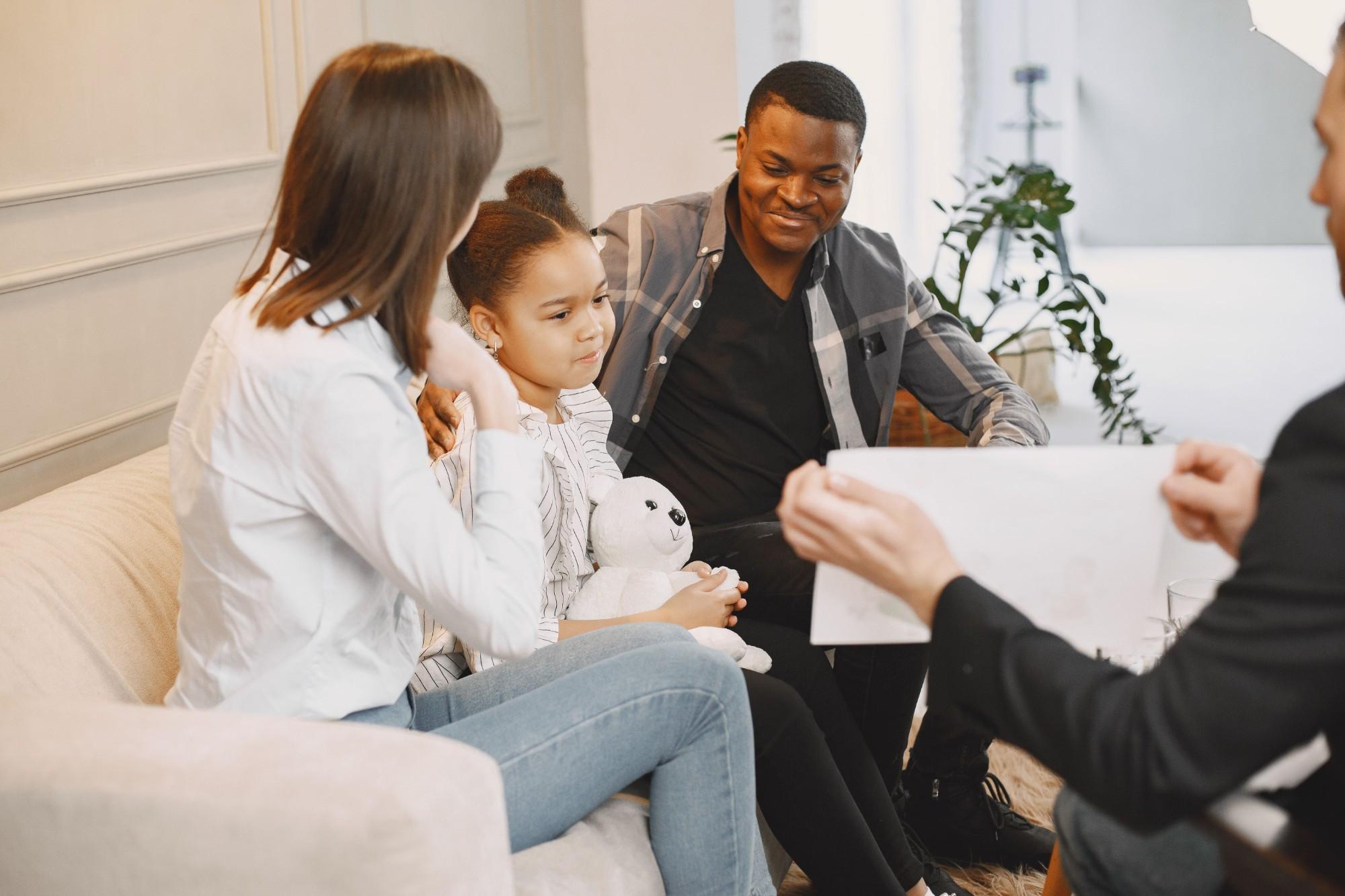 A family in a therapy session, with parents supporting their child